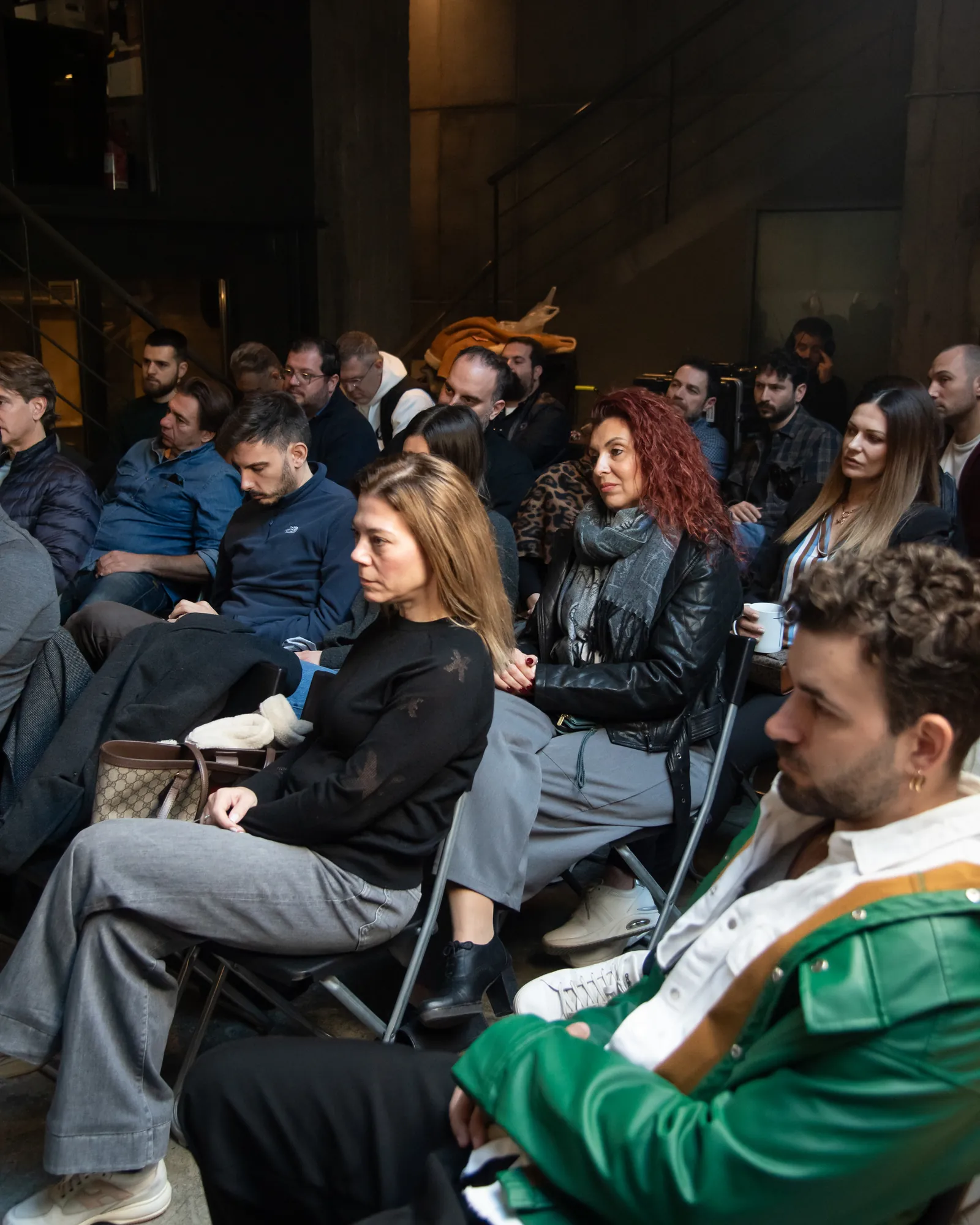 Audience members listening closely from their seats